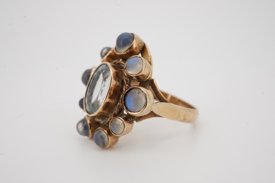 A yellow metal single stone aquamarine and nine stone cabochon moonstone set oval cluster ring, size R, gross weight 7.8grams Condition - poor to fair